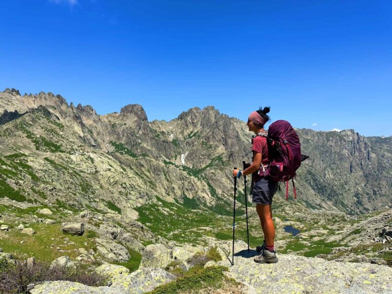 Hiker admiring panoramic views of the GR 20 trail in Corsica"
